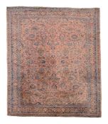 A Sarouk carpet, decorated in polychrome with scrolling floral foliage on a...