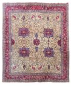 A Tabriz carpet, the ivory field centred by four blue and crimson medallions