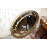 A Regency style gilt oval sectional mirror.113cm x 82cm.