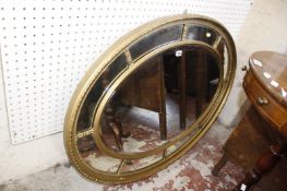A Regency style gilt oval sectional mirror.113cm x 82cm.