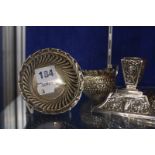 A Victorian squat silver candlestick, with repousse decoration, tapered base, Birmingham 1892, a