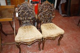 A companion pair of 19th Century parcel gilt decorated carved Continental chairs