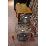 A brass club fender, a cartouche shaped metal fire guard, an iron basket grate and an iron fire