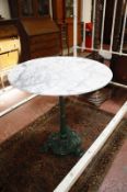 A cast iron based marble topped table.