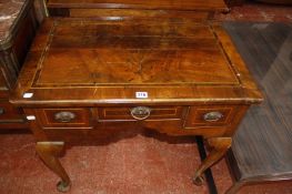 An 18th Century walnut lowboy with a crossbanded top, three frieze drawers on cabriole legs