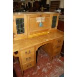 An Arts and Crafts oak bureau desk, the superstructure with hinged leather writing surface enclosing