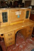 An Arts and Crafts oak bureau desk, the superstructure with hinged leather writing surface enclosing