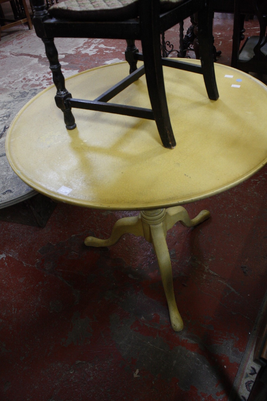 A Georgian yellow painted tripod tilt-top table 74cm high, 81cm diameter