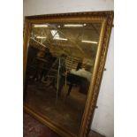A Georgian style gilt wall mirror, with ribbed cushion frame. 145cm x 166cm.