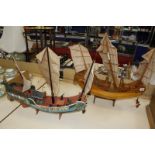 Two scale model wooden junks, one with hand painted decoration, both 57cm long approx.