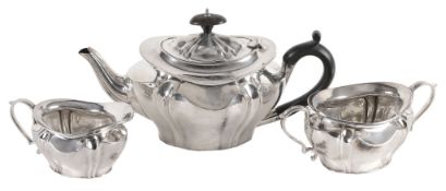 An Edwardian silver shaped oval baluster and wrythen three piece tea service...  An Edwardian silver