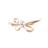 A Mikimoto cultured pearl brooch, the abstract bow with a partial cluster, stamped with the