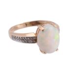 An opal and diamond ring, the central oval cabochon opal in four claw setting, with brilliant cut