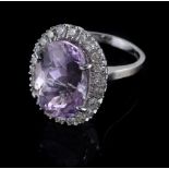 An 18 carat gold kunzite and diamond cluster ring, the central oval shaped kunzite claw set within