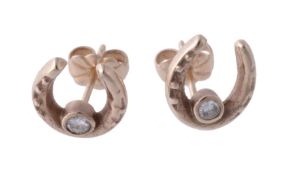 A pair of diamond set horseshoe earrings, designed as a horseshoe, each one set with a brilliant