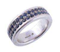 A sapphire set eternity ring by Theo Fennell , the white gold band set with two rows of round cut