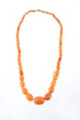 An amber bead necklace, composed of a single strand of graduated oval shaped amber beads, on a