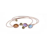Three gem set bangles, each bangle set with different gemstones to the terminals, including: