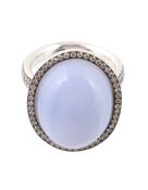 A blue agate and diamond ring, the central oval cabochon blue agate within a surround of brilliant