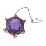 An amethyst brooch, the circular shaped amethyst within a six pointed star setting, 3.5cm diameter