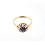 A sapphire and diamond cluster ring, the central circular shaped sapphire claw set within a