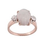 A late Victorian carved moonstone and diamond ring, the moonstone carved as a cherub's face, in a