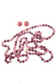 A rhodonite bead necklace and a pair of rhodonite ear clips , the uniform beads of pale and dark