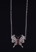 A ruby and diamond butterfly pendant, the body set with oval shaped rubies with a circular shaped