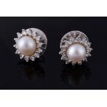 A pair of cultured pearl and diamond earrings, the cultured pearls set within a surround of