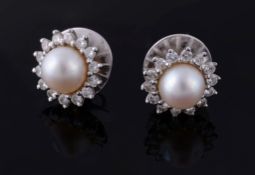 A pair of cultured pearl and diamond earrings, the cultured pearls set within a surround of