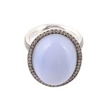 A blue agate and diamond ring, the central oval cabochon blue agate within a surround of brilliant