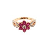 A ruby and diamond cluster ring, the central brilliant cut diamond claw set within a surround of