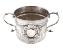 A Queen Anne silver porringer by Nathaniel Lock, London 1704, Britannia standard, with leaf-capped