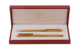 Cartier, Les Must de Cartier, a ballpoint pen and a pencil set,   both with ridged detail and a
