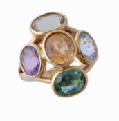 A multi gem set dress ring, the central oval shaped citrine collet set within a surround of