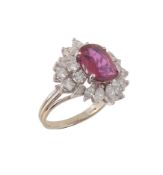 A ruby and diamond cluster ring, the oval cut ruby estimated to weigh 1.94 carats, within a