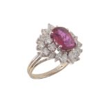 A ruby and diamond cluster ring, the oval cut ruby estimated to weigh 1.94 carats, within a