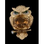 A gem set owl brooch by Cartier, circa 1960, with a mixed cut citrine set body, and emerald and