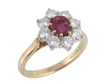 An 18 carat gold ruby and diamond ring by Garrard & Co., the central oval shaped ruby claw set