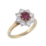 An 18 carat gold ruby and diamond ring by Garrard & Co., the central oval shaped ruby claw set