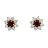 A pair of ruby and diamond ear studs by Garrard & Co., the circular shaped ruby in a claw setting