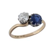 A diamond and sapphire crossover ring, set with an old cut diamond, estimated to weigh 0.65 carats,