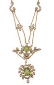 An Edwardian peridot and half pearl necklace, circa 1910, the oval shaped peridot in a cut down