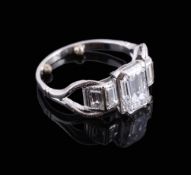 A diamond ring, the central emerald cut diamond weighing 1.70 carats, above graduated step cut