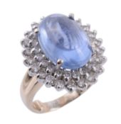 A sapphire and diamond ring, the oval shaped cabochon Burmese sapphire, stated to weigh 12.36
