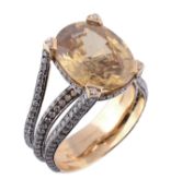 A yellow zircon and diamond ring, the central oval shaped yellow zircon in a four claw setting