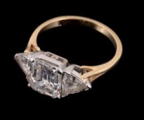 A three stone diamond ring, the central emerald cut diamond ring, stated to weigh 2.04 carats, in a