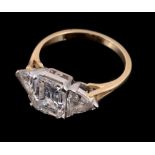 A three stone diamond ring, the central emerald cut diamond ring, stated to weigh 2.04 carats, in a