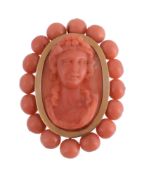 A 19th century French coral cameo brooch, circa 1860, the central oval panel carved as the head of