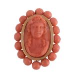 A 19th century French coral cameo brooch, circa 1860, the central oval panel carved as the head of